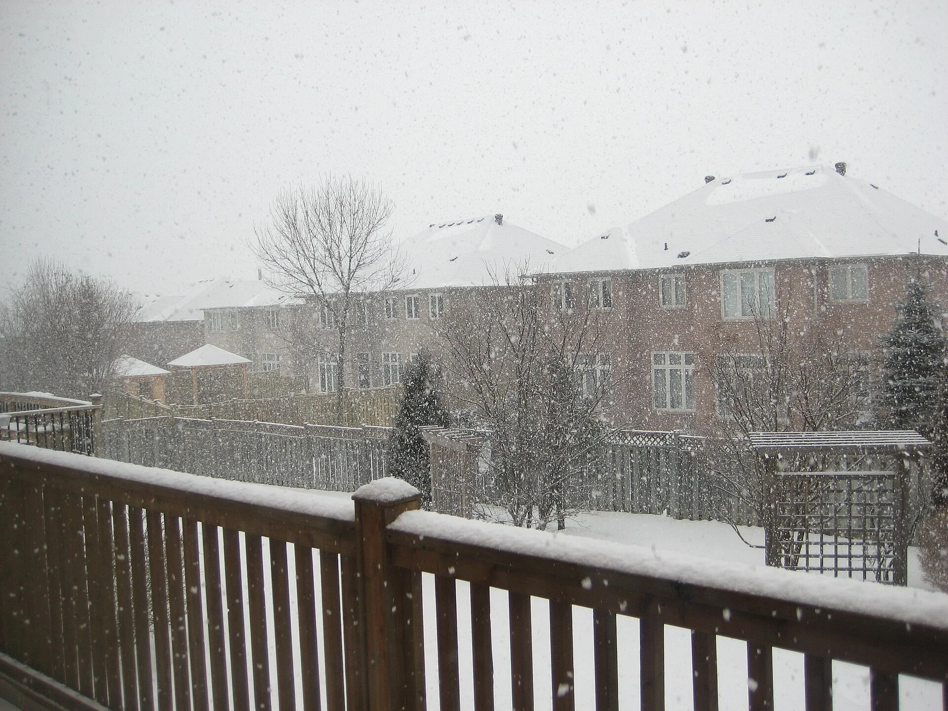 Snow falls on rows of townhouses and backyard fences in a Markham neighbourhood