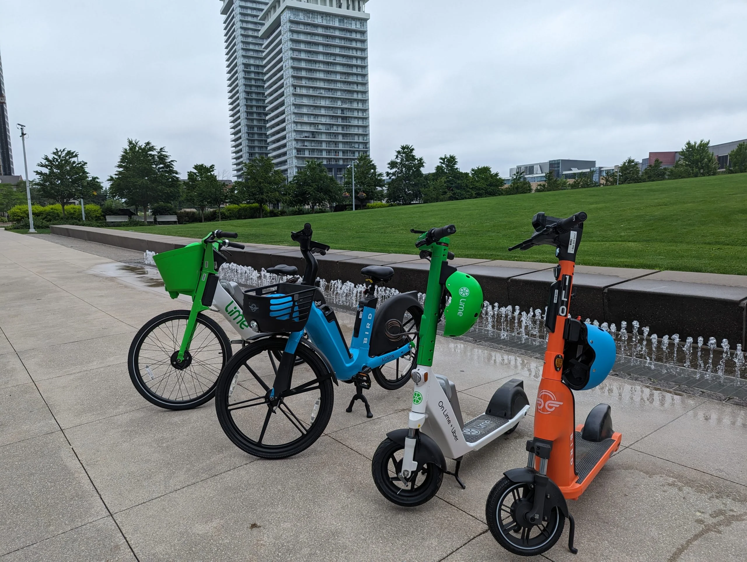 Shared e-bikes and e-scooters parked on a plaza in downtown Mississauga