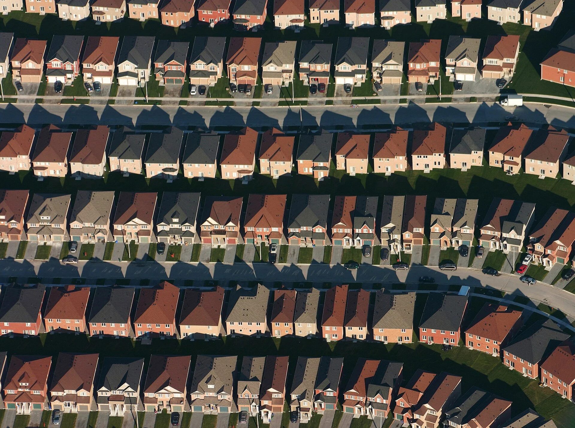 Aerial view of curving streets lined with rows of detached houses in a Markham subdivision