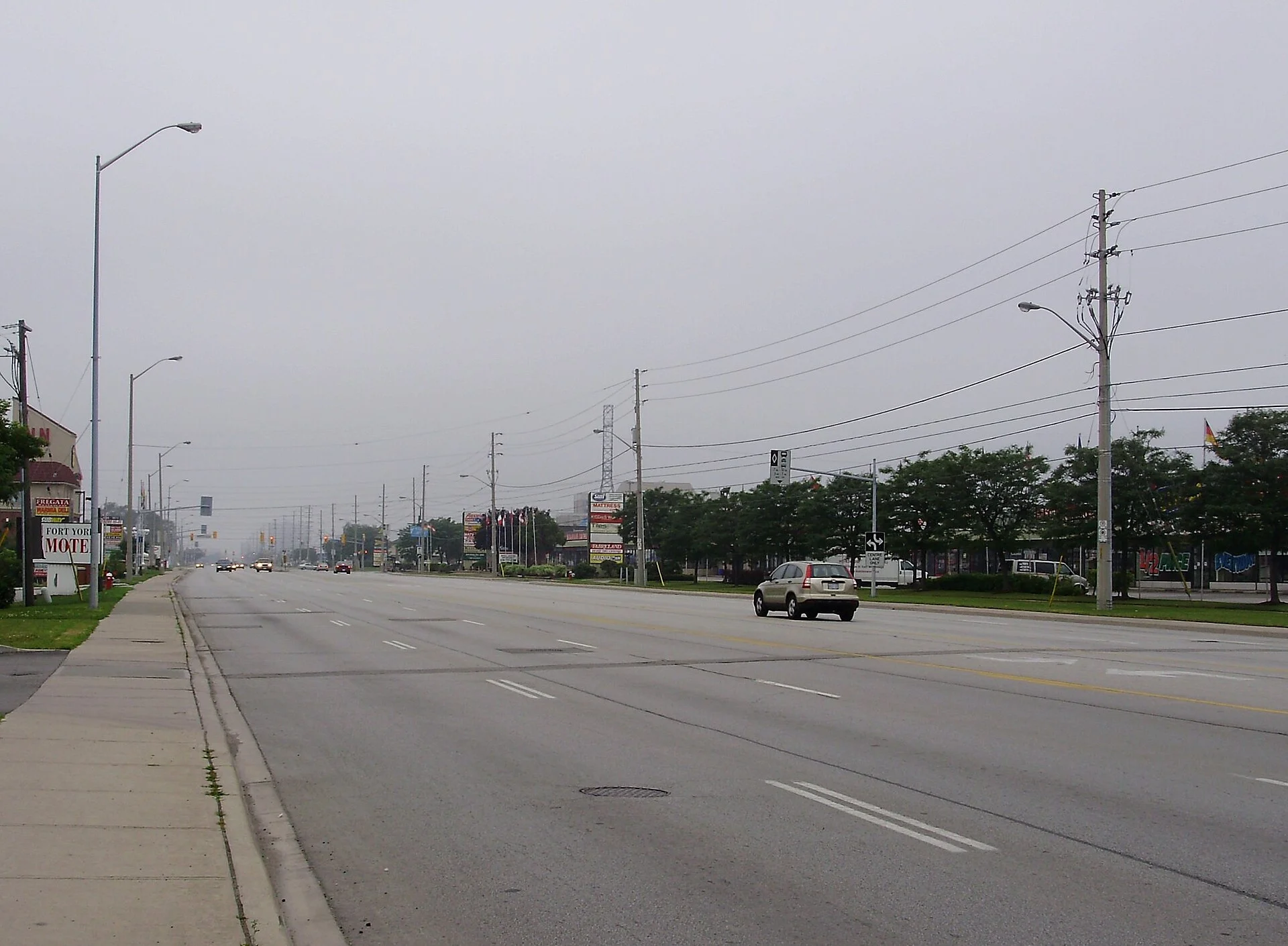 A wide stretch of Dundas Street East lined with plazas in east Mississauga on an overcast day