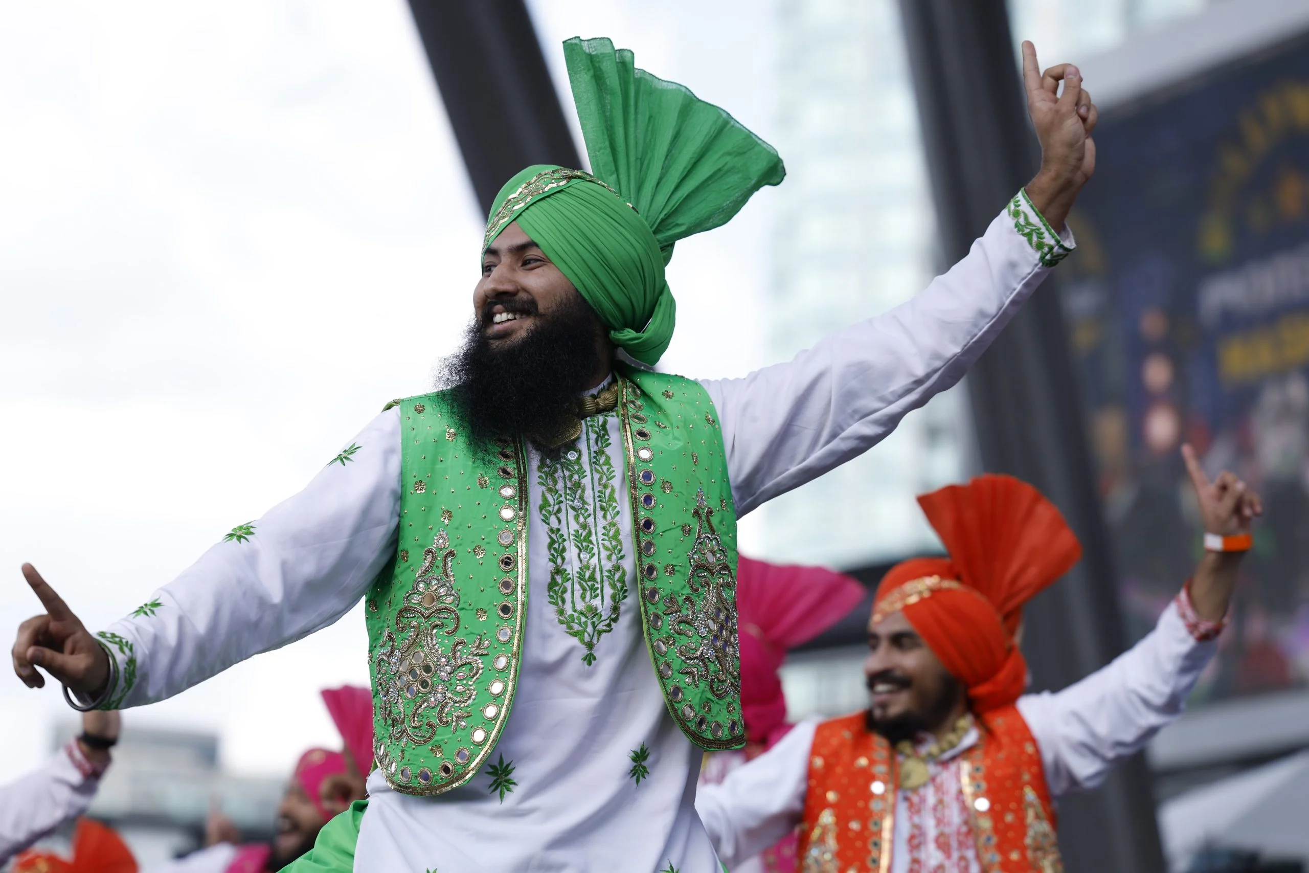 Dancers in bright turbans and embroidered vests perform at an outdoor festival in downtown Mississauga