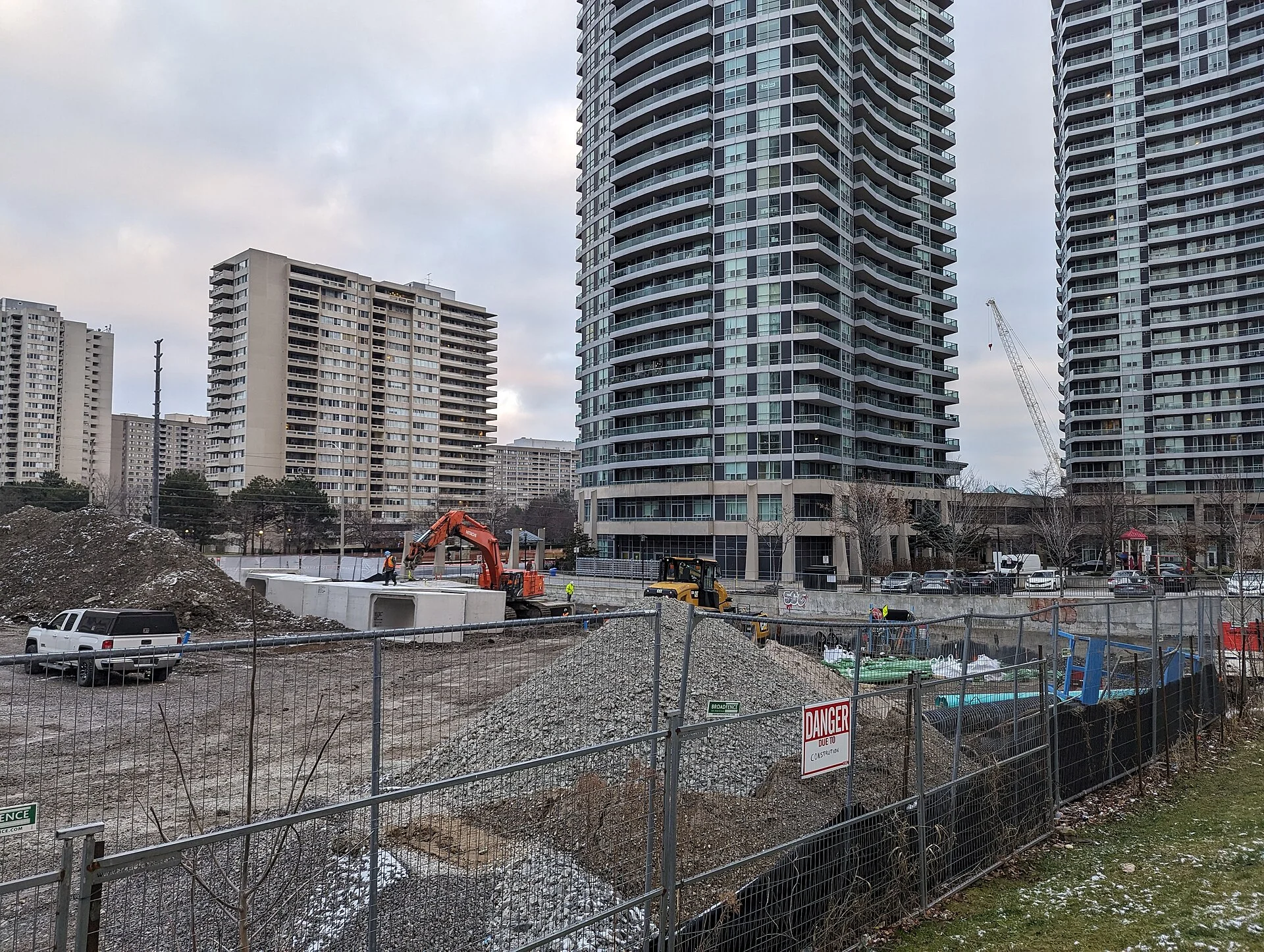 A fenced construction site beside residential towers along Hurontario Street in Mississauga
