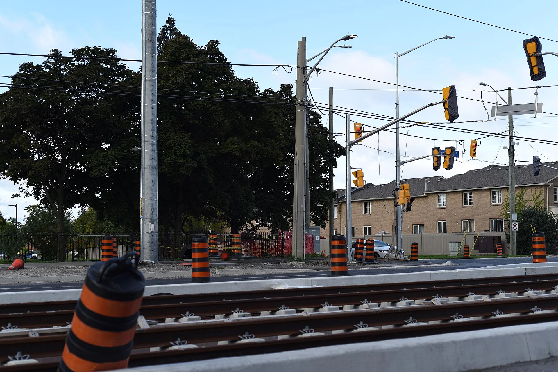 New light rail tracks lined with orange construction barrels along Hurontario Street in Mississauga