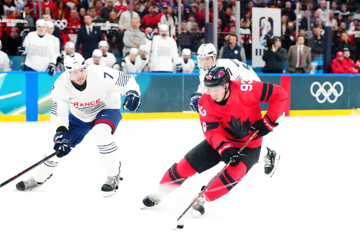 Canada's Mitch Marner, wearing No. 93, carries the puck past a French player at the Milano Cortina 2026 Olympic Winter Games