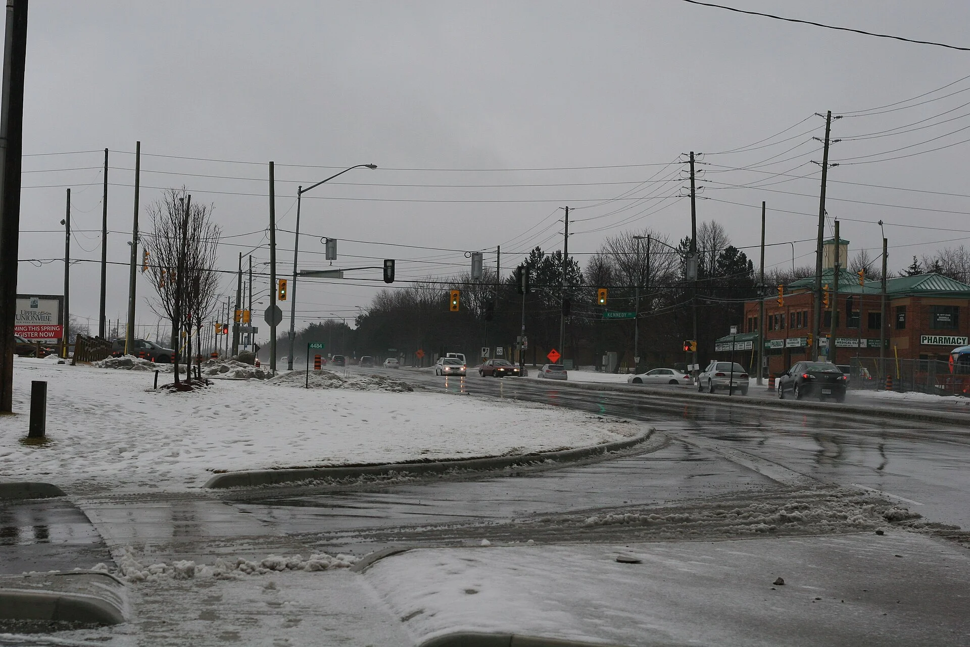 Slush and melting snowbanks along 16th Avenue at Kennedy Road in Markham on a grey late-winter day