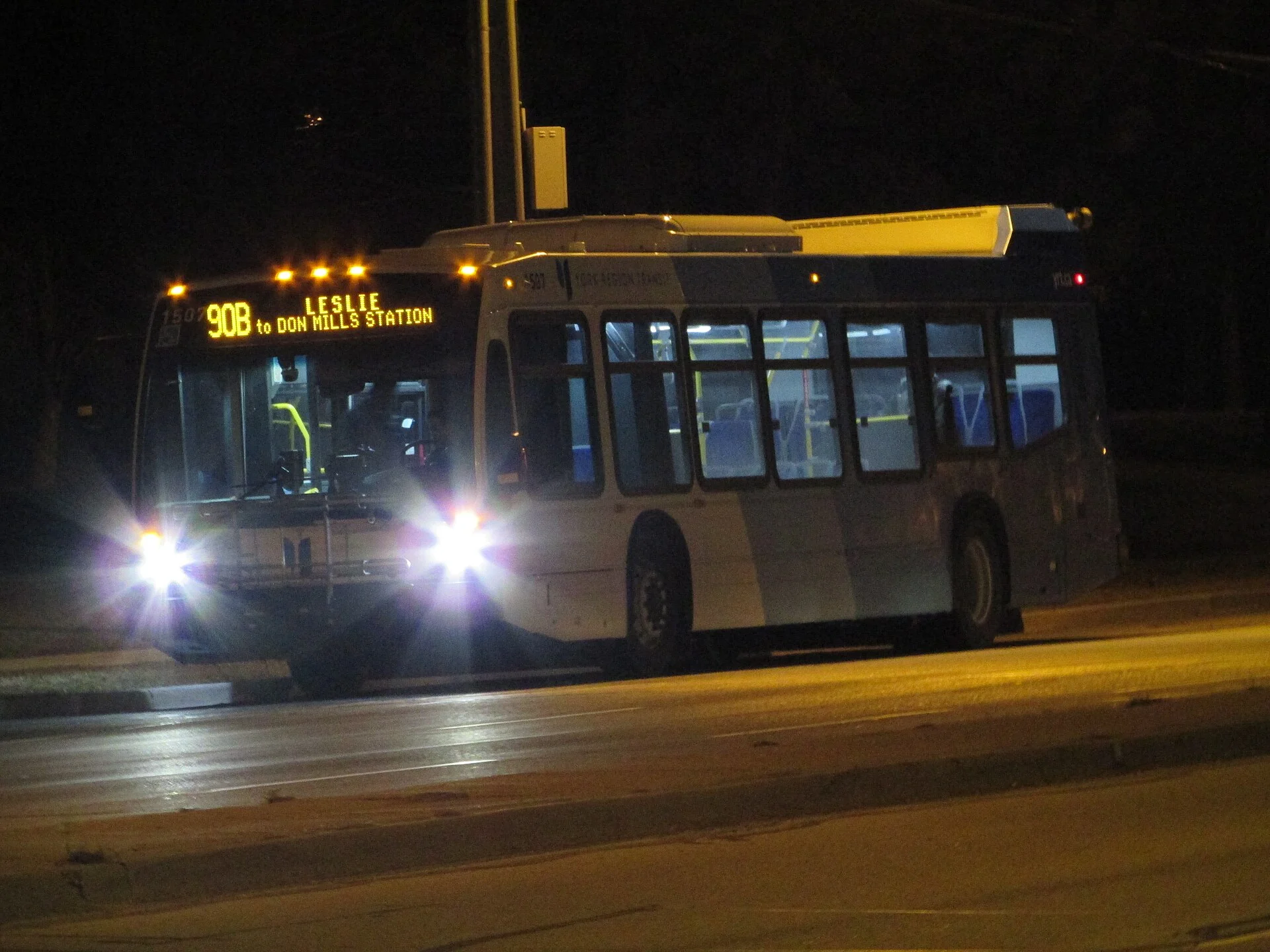 A York Region Transit bus on route 90B Leslie, headlights on, travelling at night