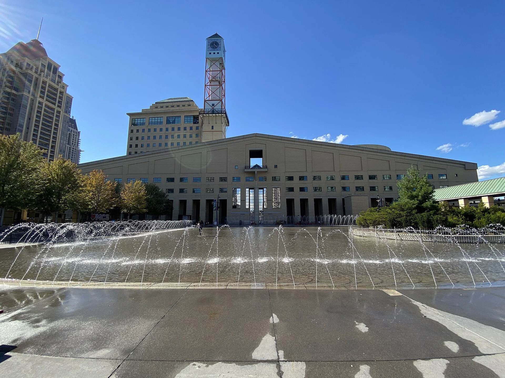 Mississauga City Hall and its clock tower, seen across the fountain at Celebration Square on a sunny day