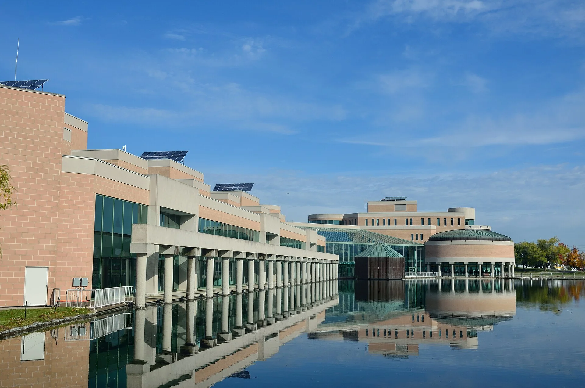 Markham Civic Centre and its round council chamber reflected in the pond out front on a clear day