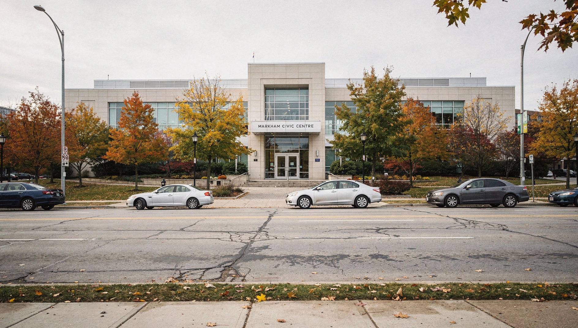The exterior of the Markham Civic Centre during autumn with colorful fall leaves on the trees.