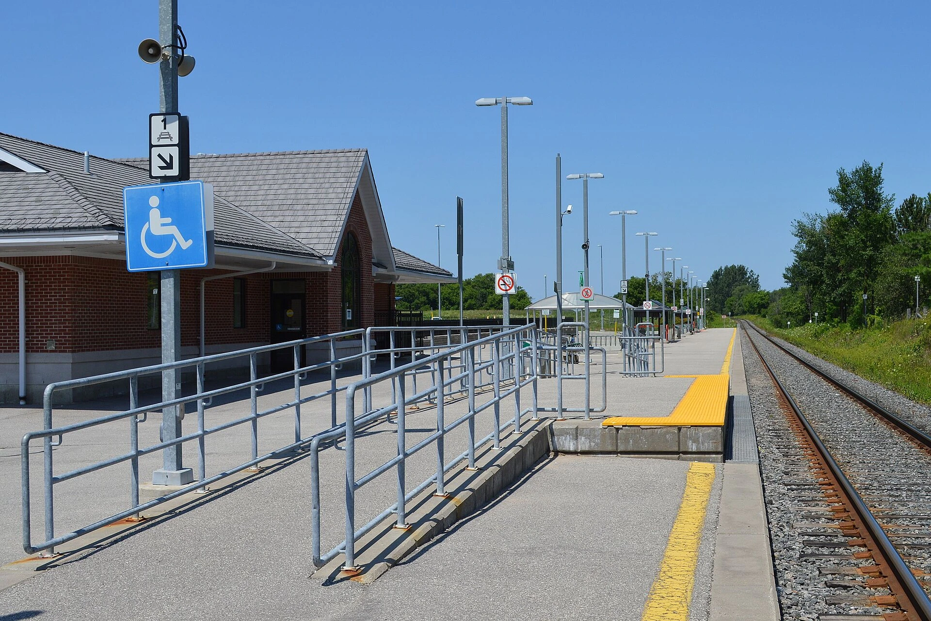 A commuter train stopped at a transit platform during an autumn afternoon in Ontario.