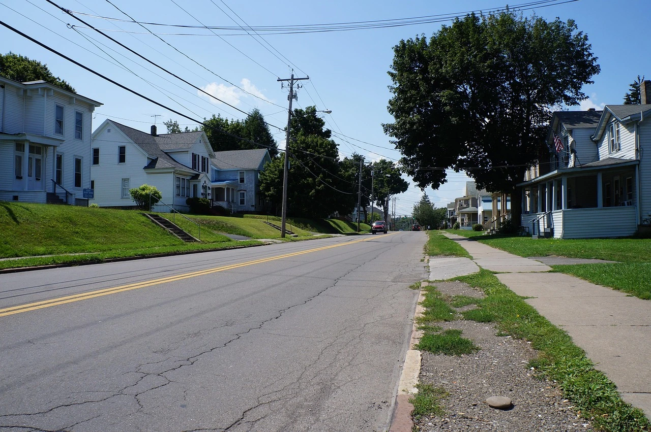 A residential street in Thorold, Ontario, showing a section of road with utility poles and autumn leaves on the ground.