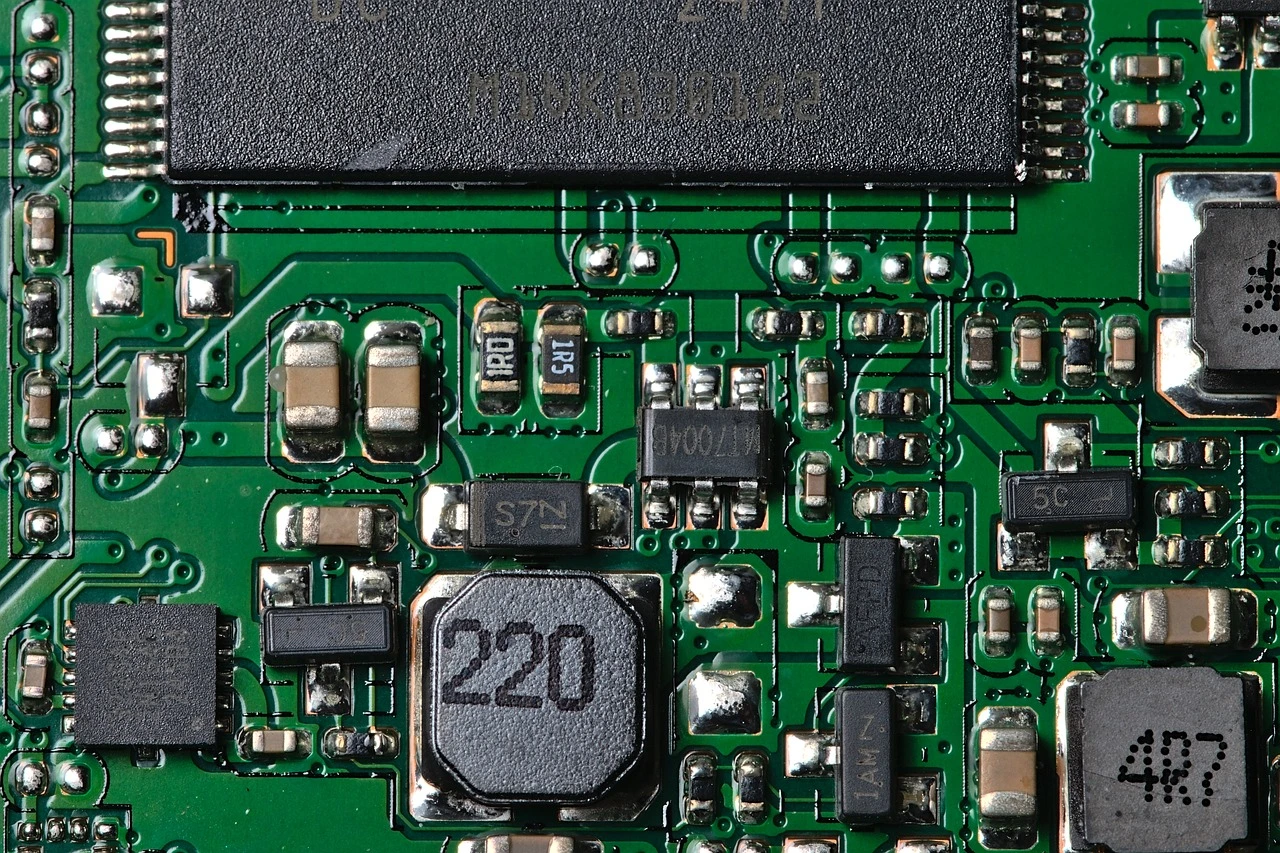 Circuit board and electronic testing equipment on a workbench in a technology office.