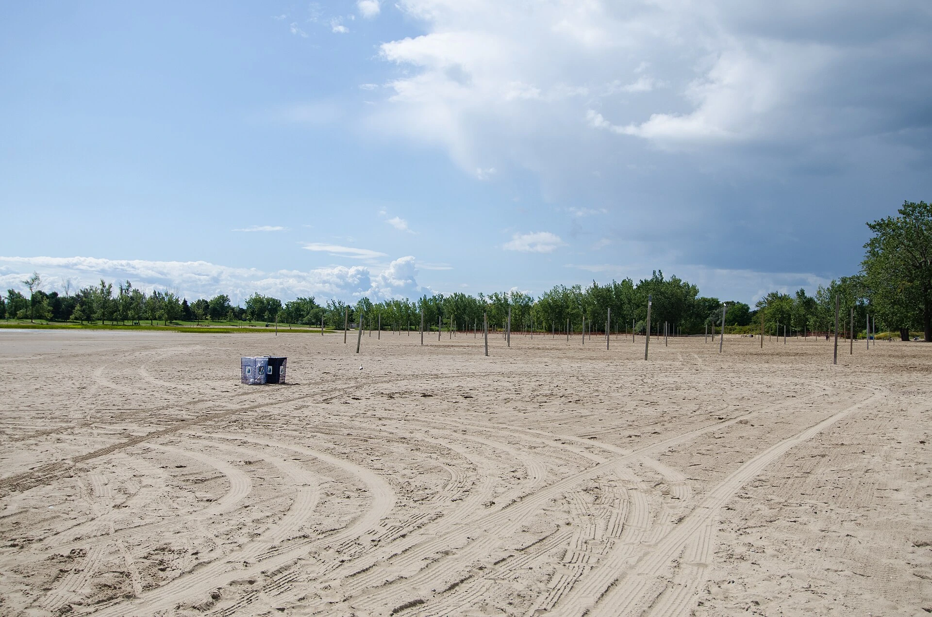 A view of the boardwalk and sandy shore at Woodbine Beach on a sunny spring day.