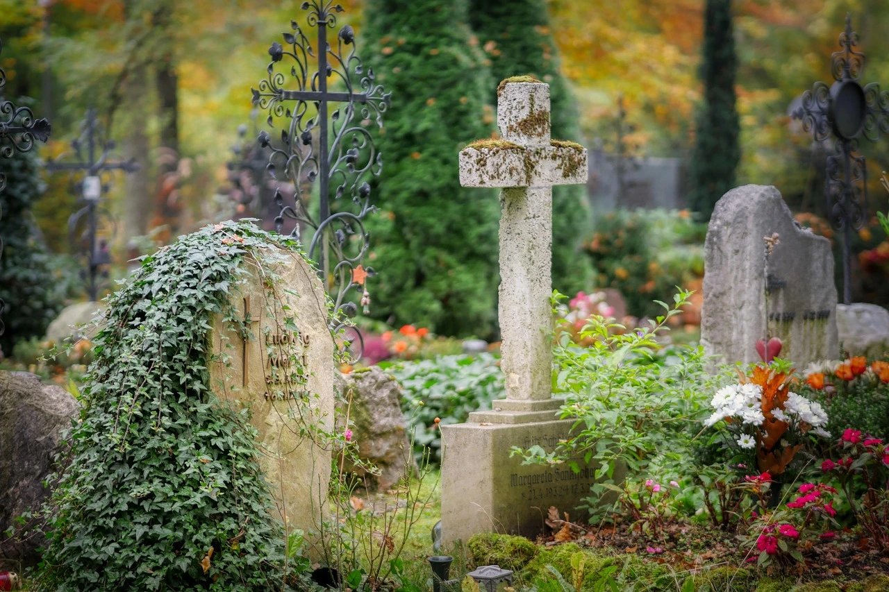 A drone flies over a small Ontario cemetery with autumn leaves on the ground.