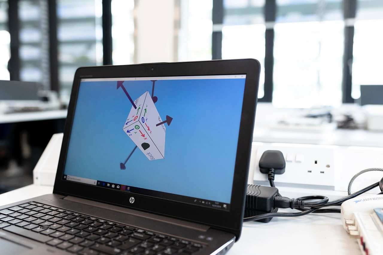 Researcher viewed from behind using a computer with a scientific diagram in a laboratory.