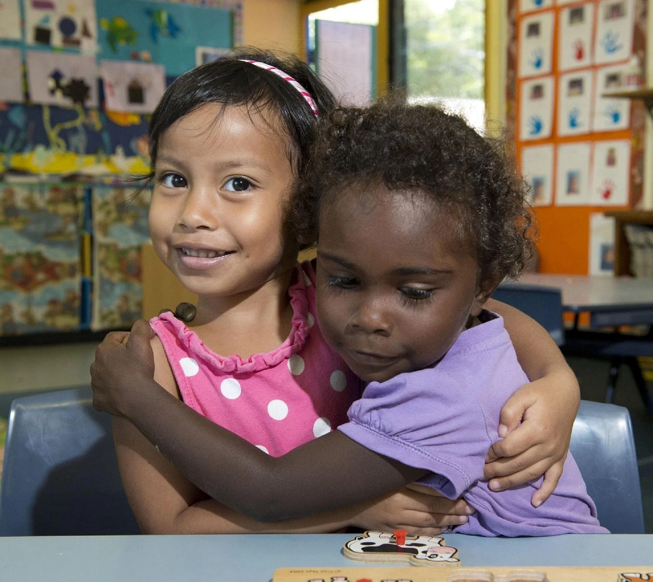 A child care classroom in a Durham Region community centre, with a low activity table, small chairs and children's artwork on the wall.