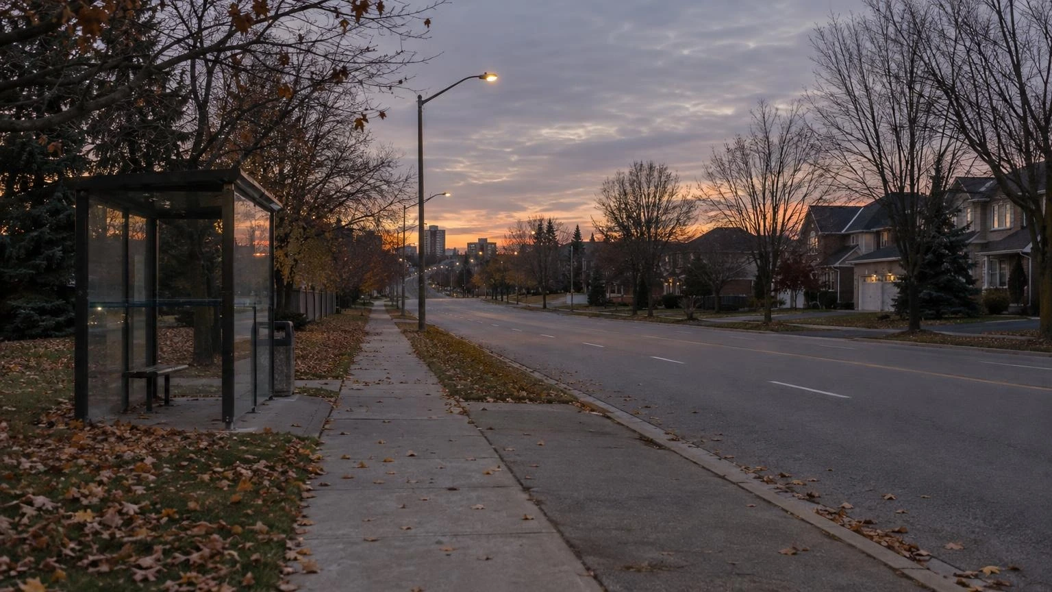 An empty residential sidewalk and street in a suburban Ontario neighbourhood at dusk during autumn.