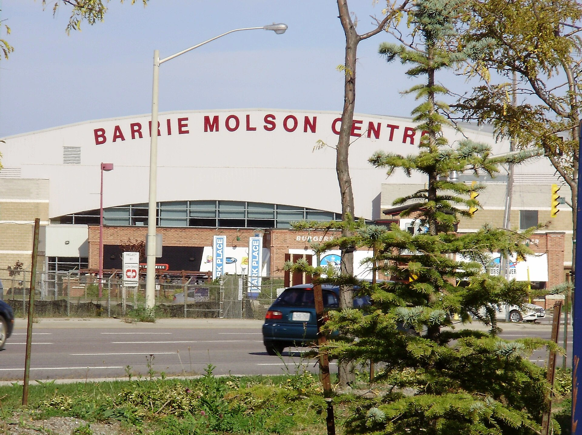 A view of an Ontario junior hockey arena with freshly cleaned ice and boards under arena lights.