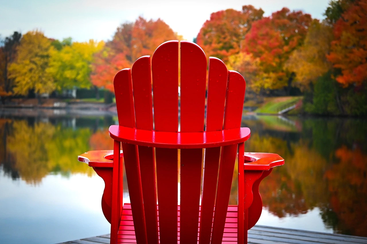 A lakeside Ontario resort scene in autumn, with a wooden dock and lodge among colourful maple trees.