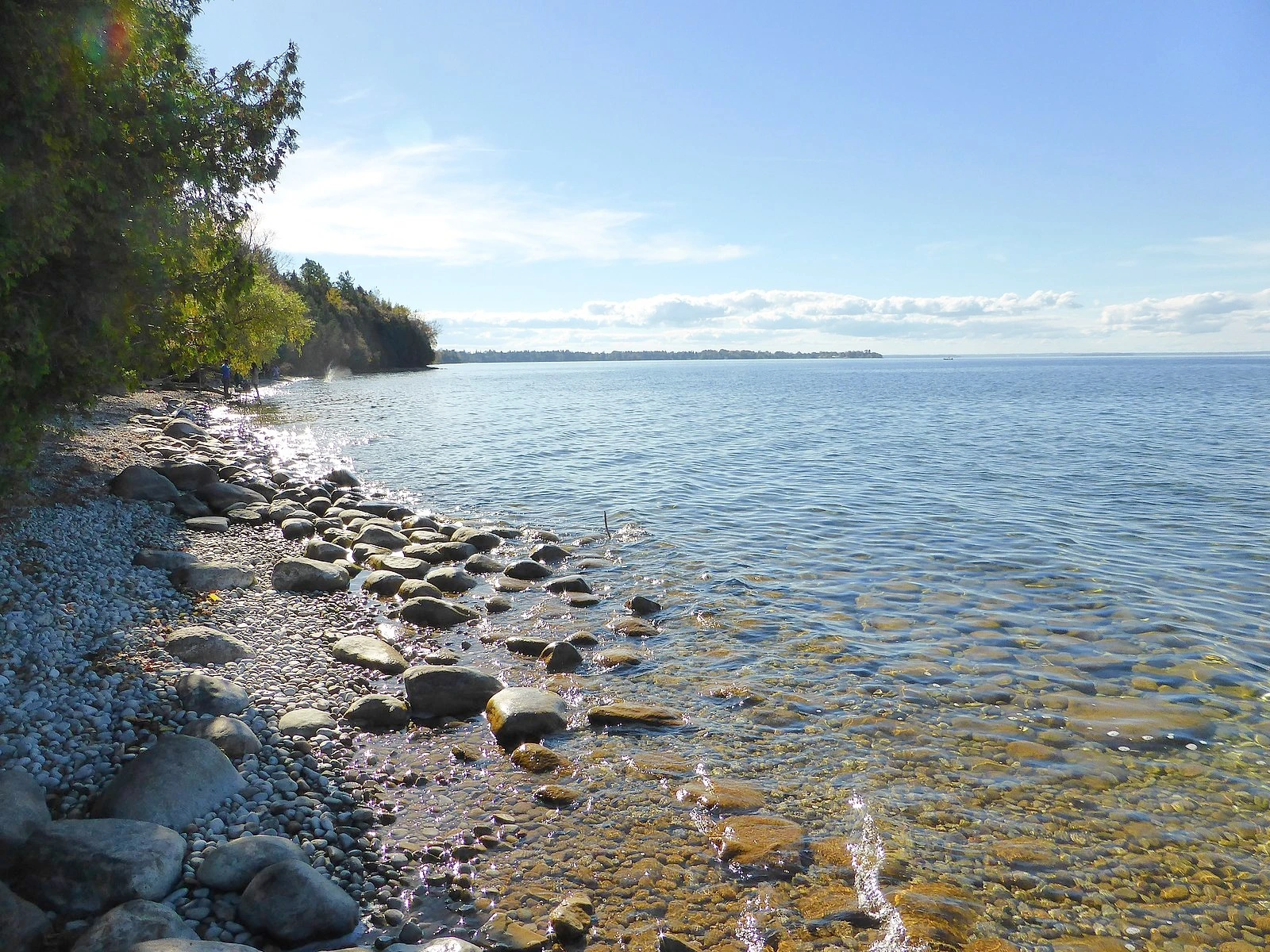 Snow-covered shoreline and open water on Lake Simcoe under an overcast winter sky