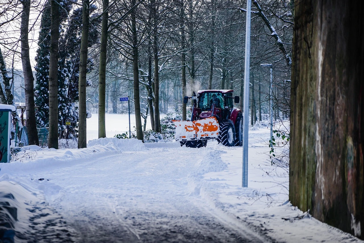 A snow plow driving down a residential street in Mississauga during winter.