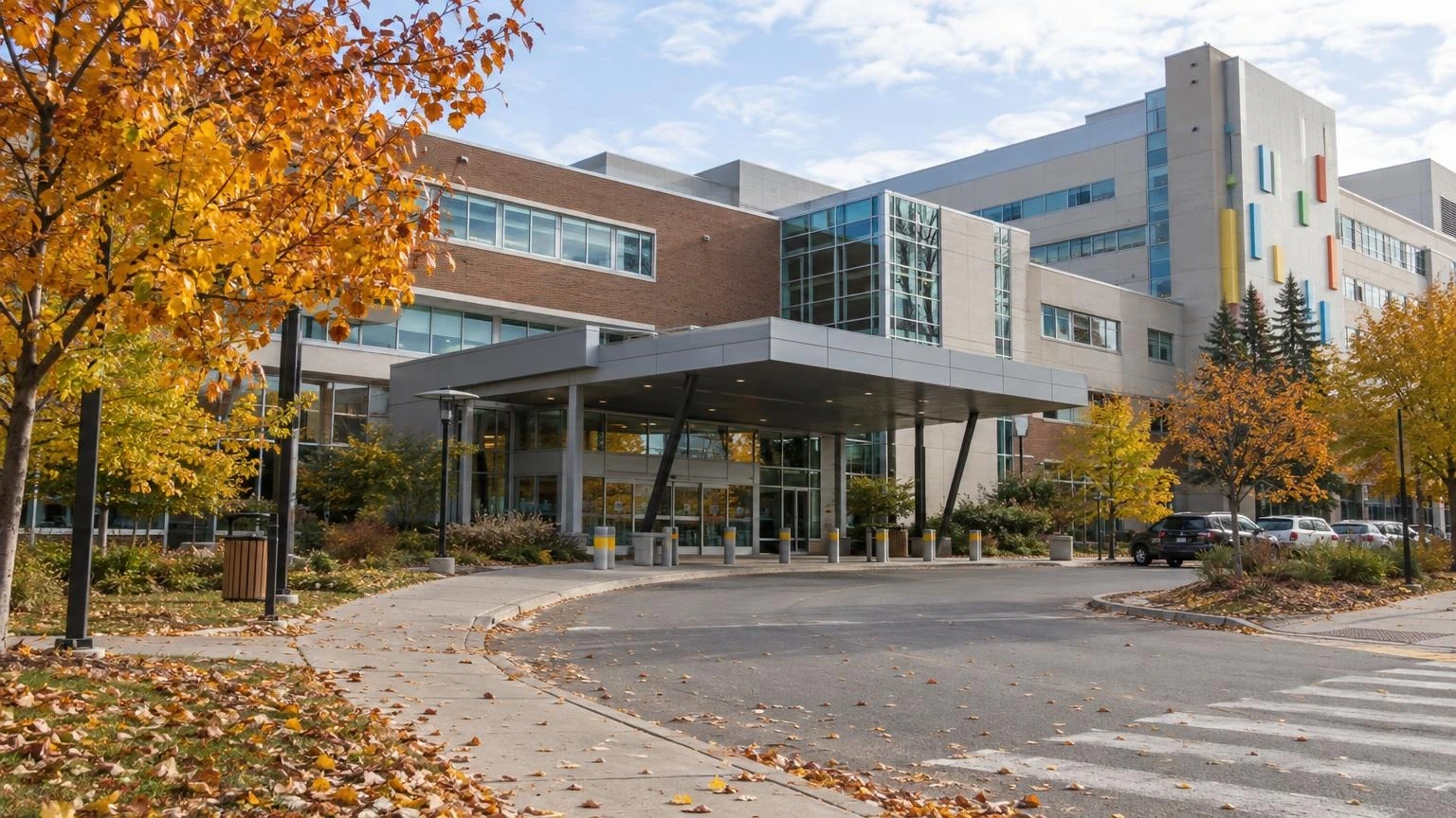 The exterior entrance of the Children's Hospital of Eastern Ontario (CHEO) with autumn leaves on the ground.