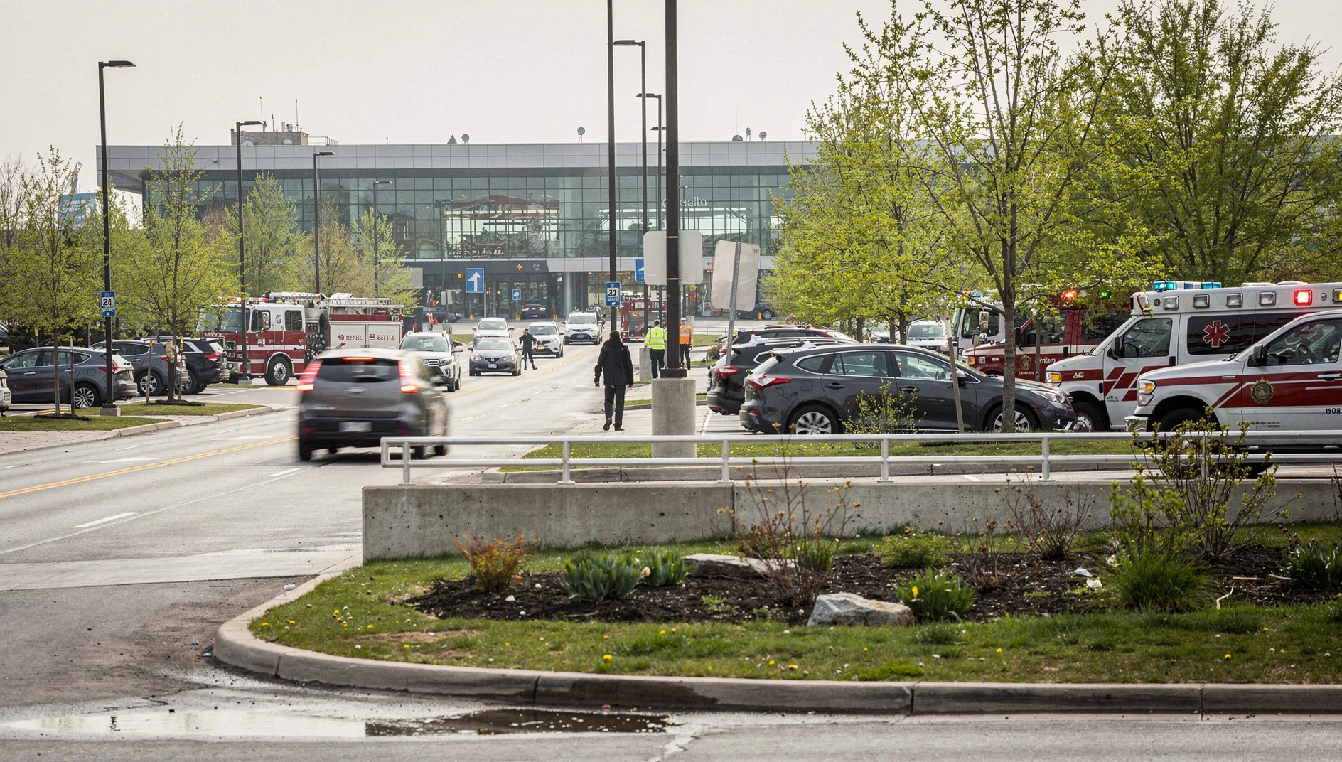 Illustration of emergency vehicles near an Ottawa airport terminal on a spring morning.