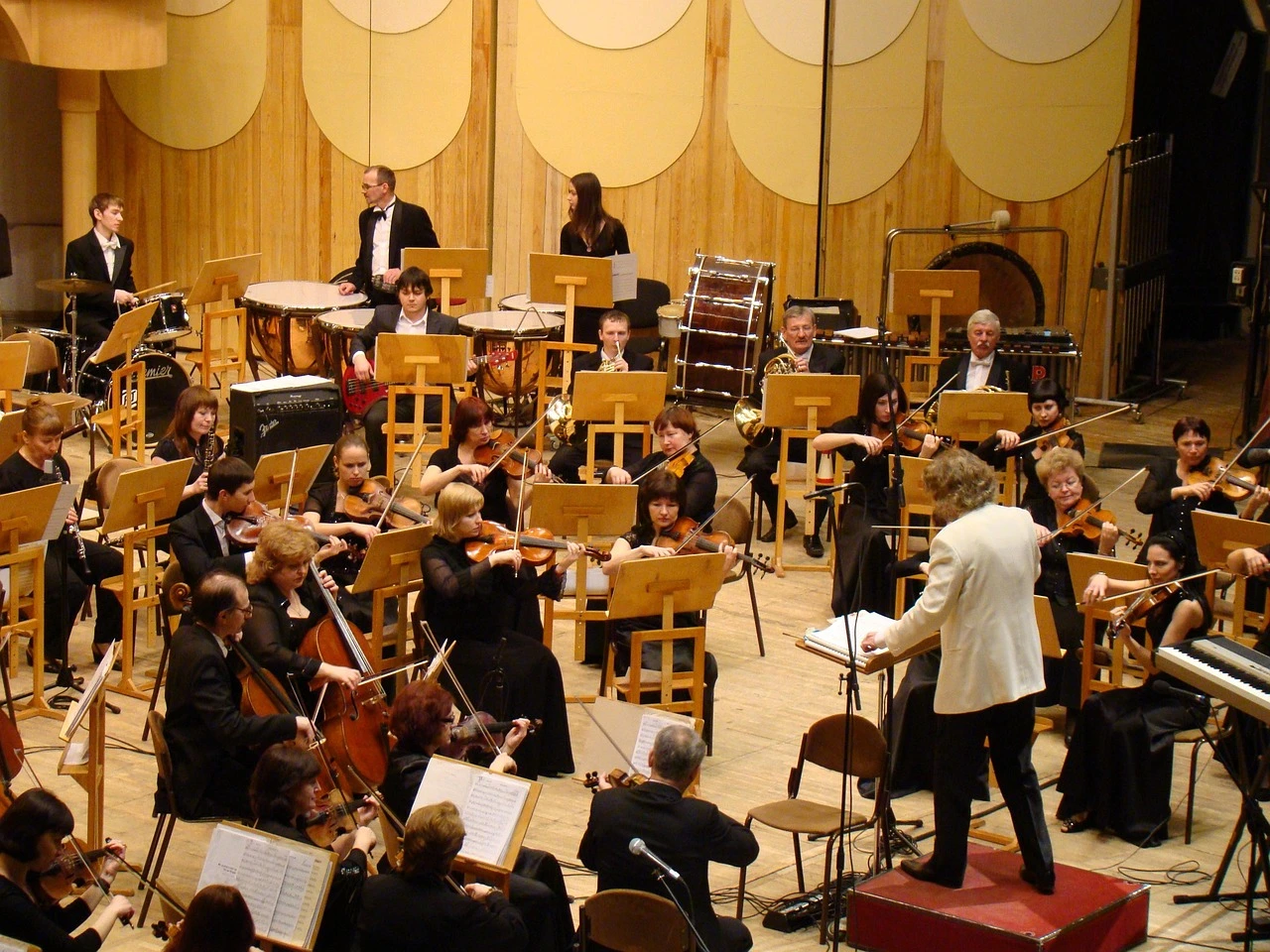 A symphony orchestra performs on a concert hall stage with rows of seats in a Toronto venue.
