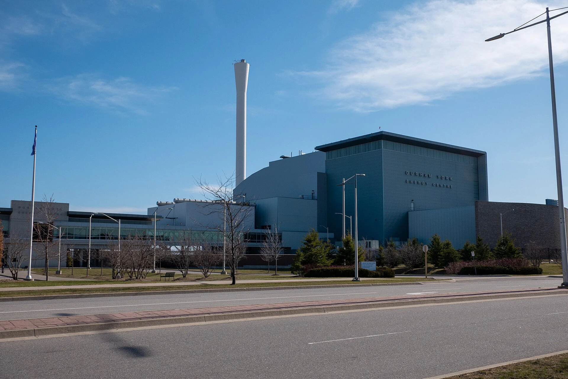 The Durham York Energy Centre, an industrial waste-to-energy facility with a tall stack, photographed in autumn with trees in fall colour.