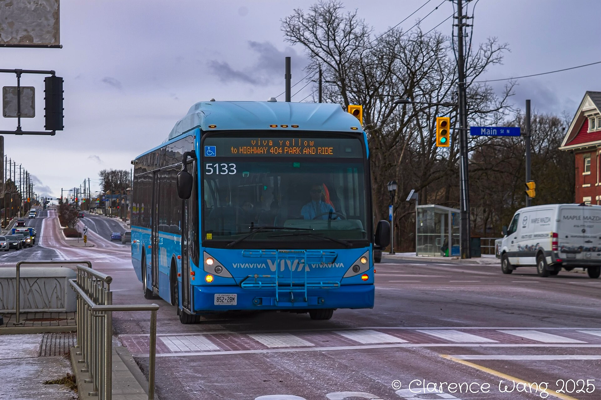 A covered suburban bus rapid transit station with autumn leaves on the ground on an overcast fall day.