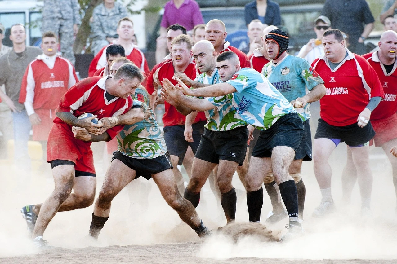 Students practising rugby drills with coaches on a university sports field