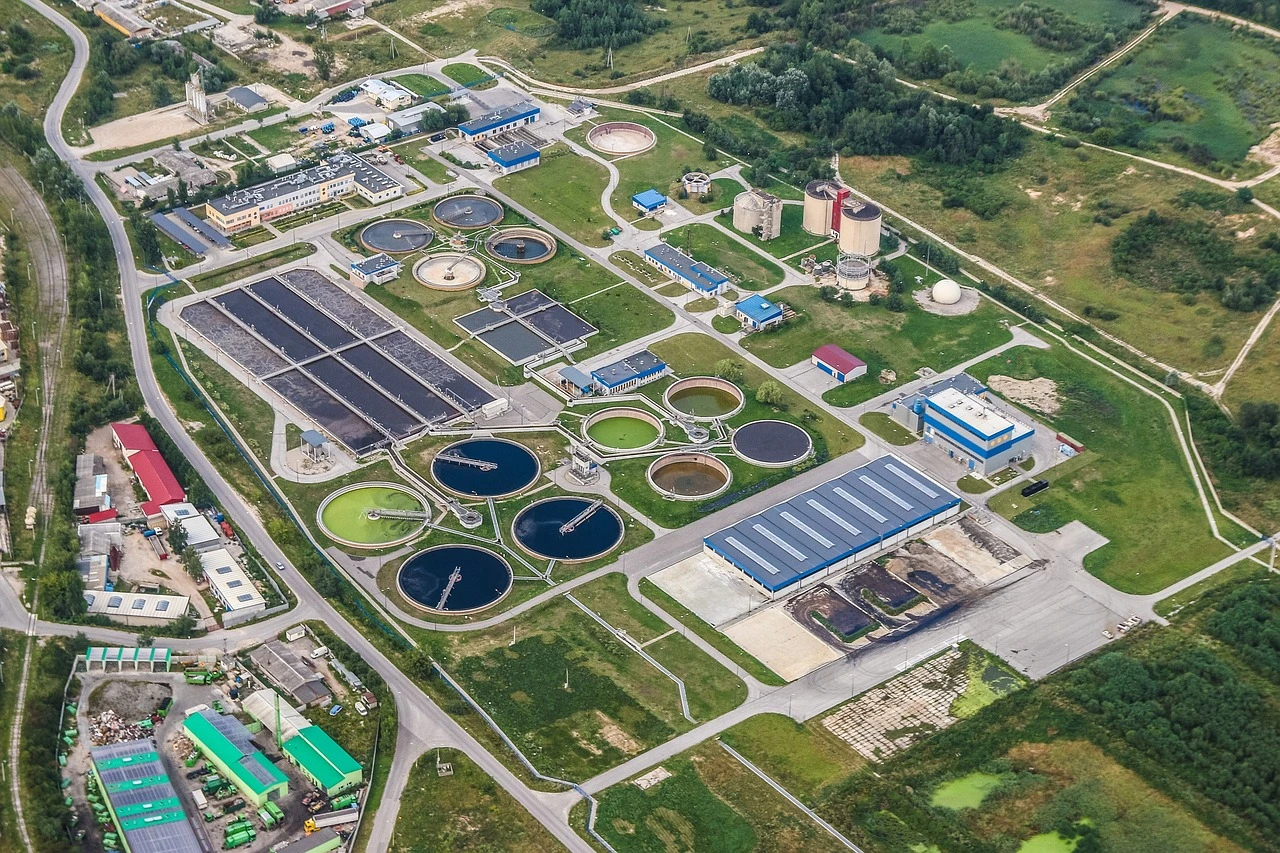 An Ontario wastewater treatment plant with clarifier tanks and concrete process buildings on an overcast autumn day.