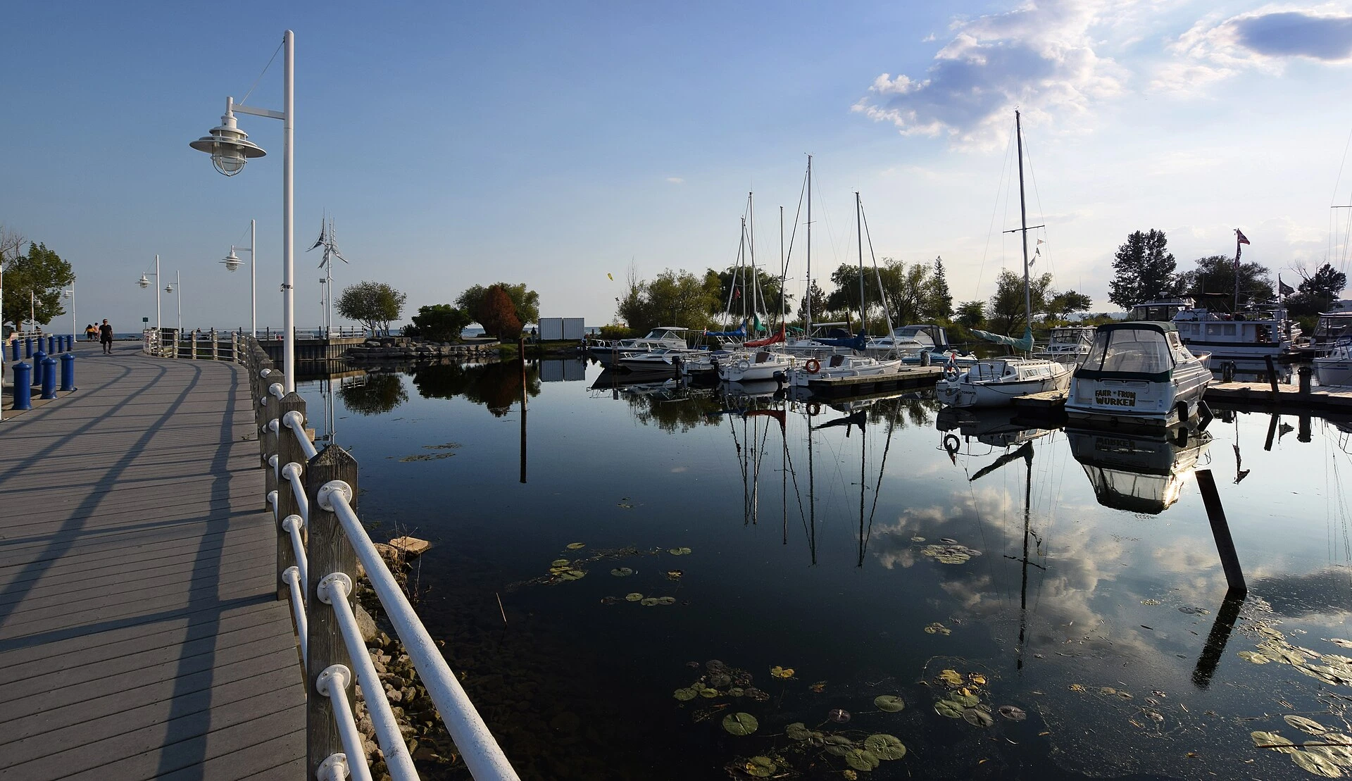 An autumn view of a coastal wetland and harbour at Frenchman's Bay in Pickering, with marsh grasses, boats at dock and Lake Ontario beyond.