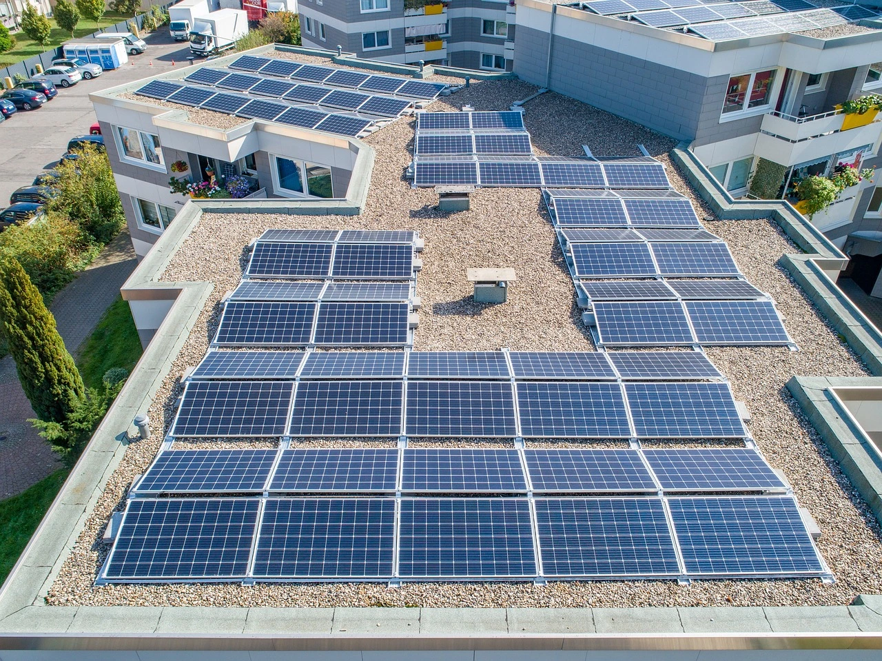 A suburban community centre with rooftop solar panels surrounded by autumn trees.