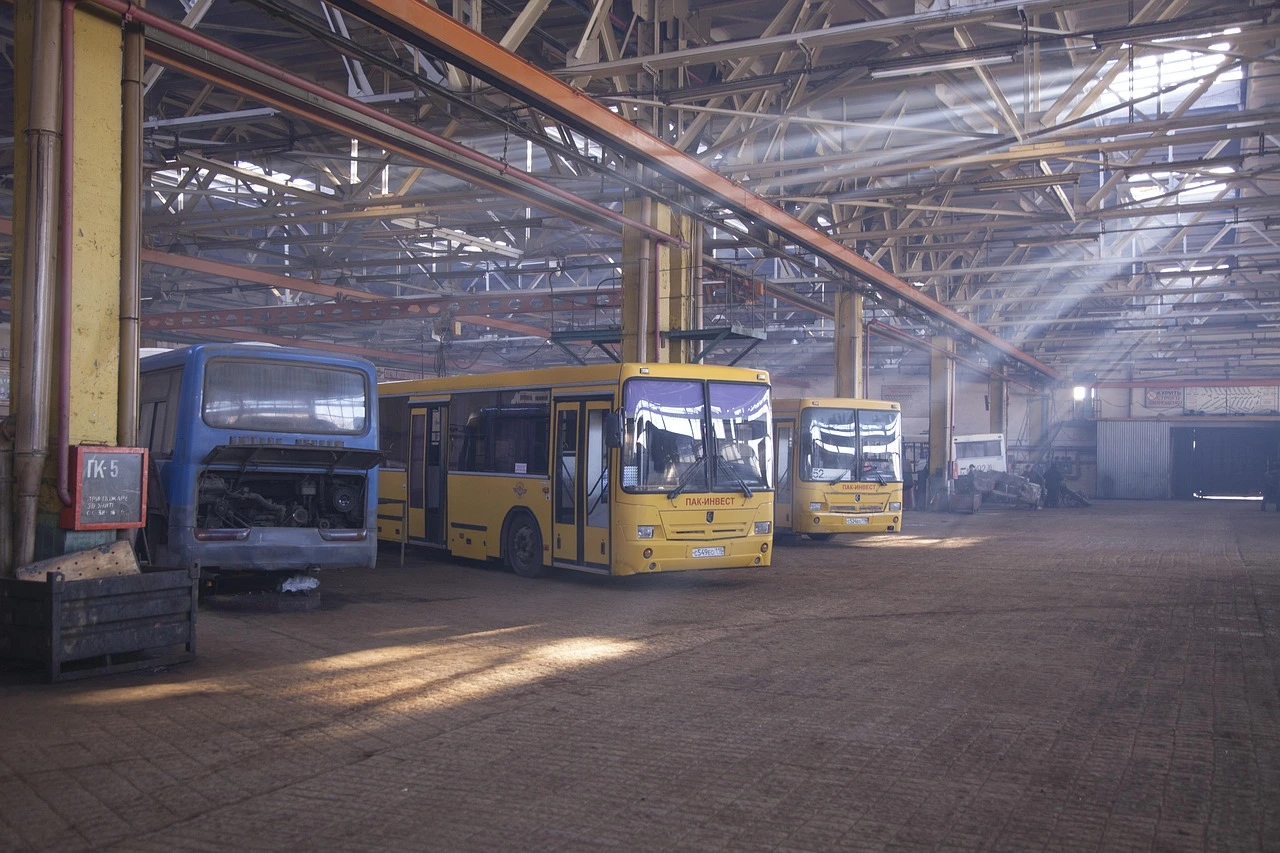 An illustration of a MiWay bus and a transit garage facility under a cloudy winter sky.