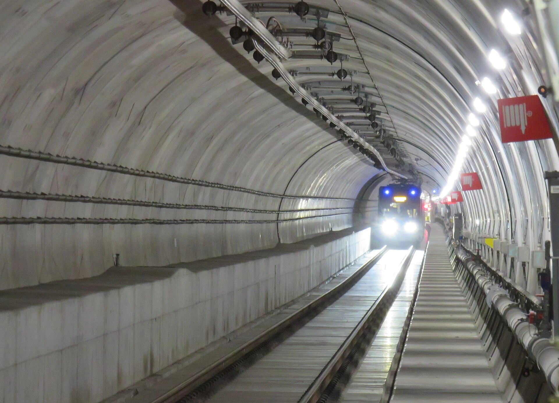 A modern light rail vehicle stopped at a bright, clean subway station platform in Toronto.