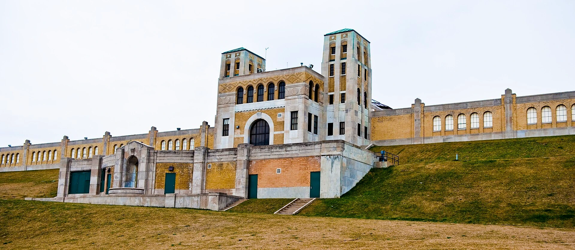Illustration of the Art Deco exterior of Toronto’s R.C. Harris Water Treatment Plant with green lawns and spring foliage.