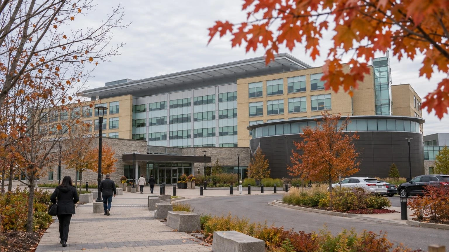 Fall scene outside a regional municipal headquarters building in Whitby, Ontario, with visitors walking toward the entrance.
