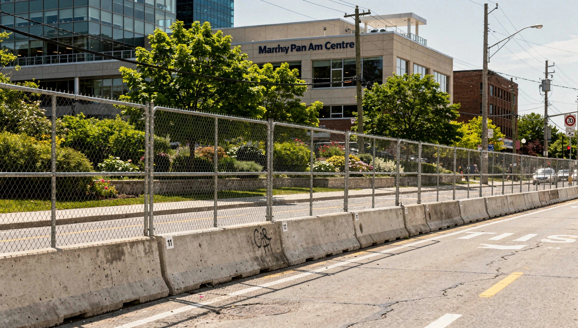 Illustration of concrete race barriers and protective fencing beside a downtown Markham road in summer.