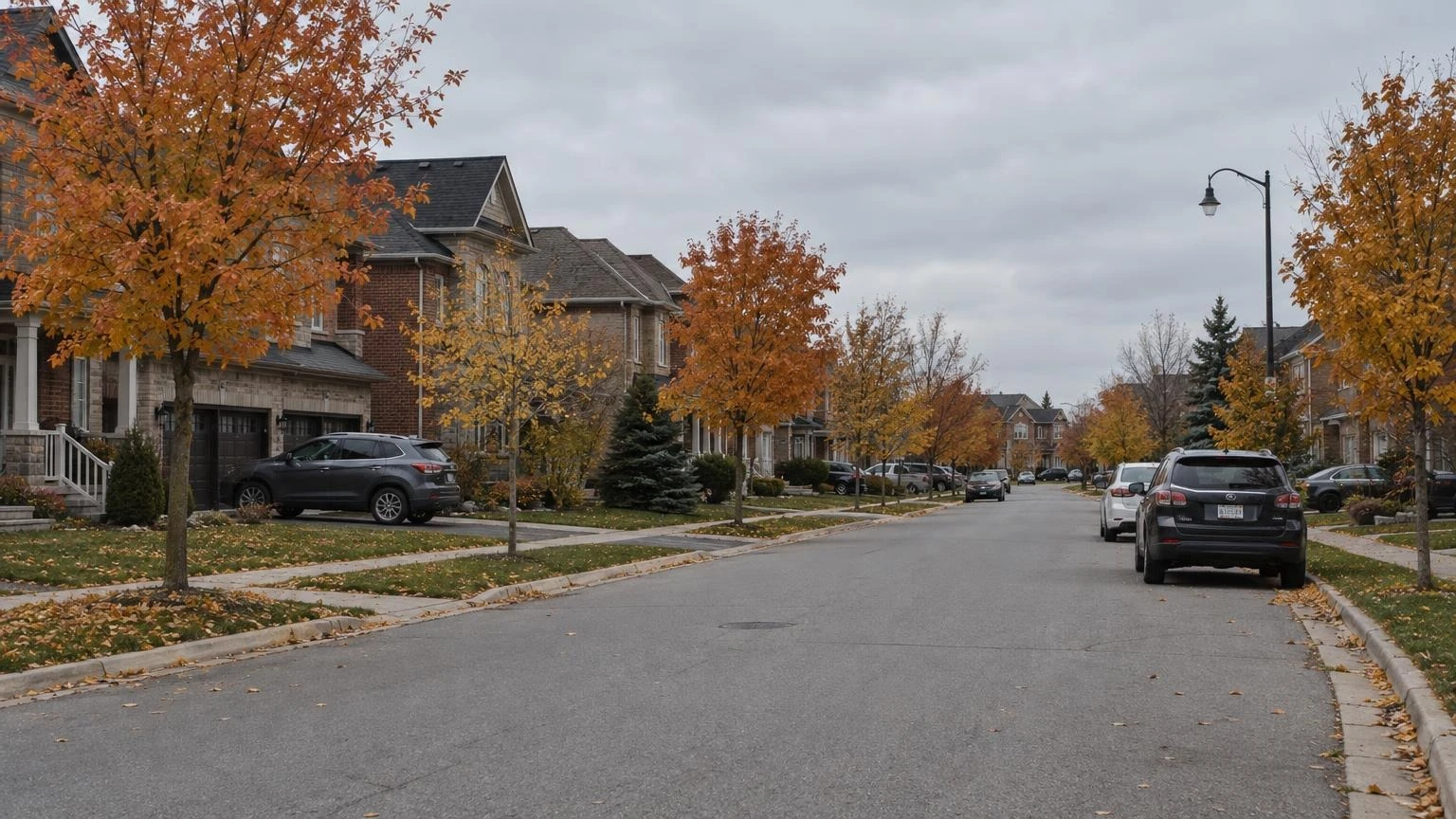 A quiet suburban residential street in Caledon, Ontario, with autumn leaves on the ground and houses in the background.