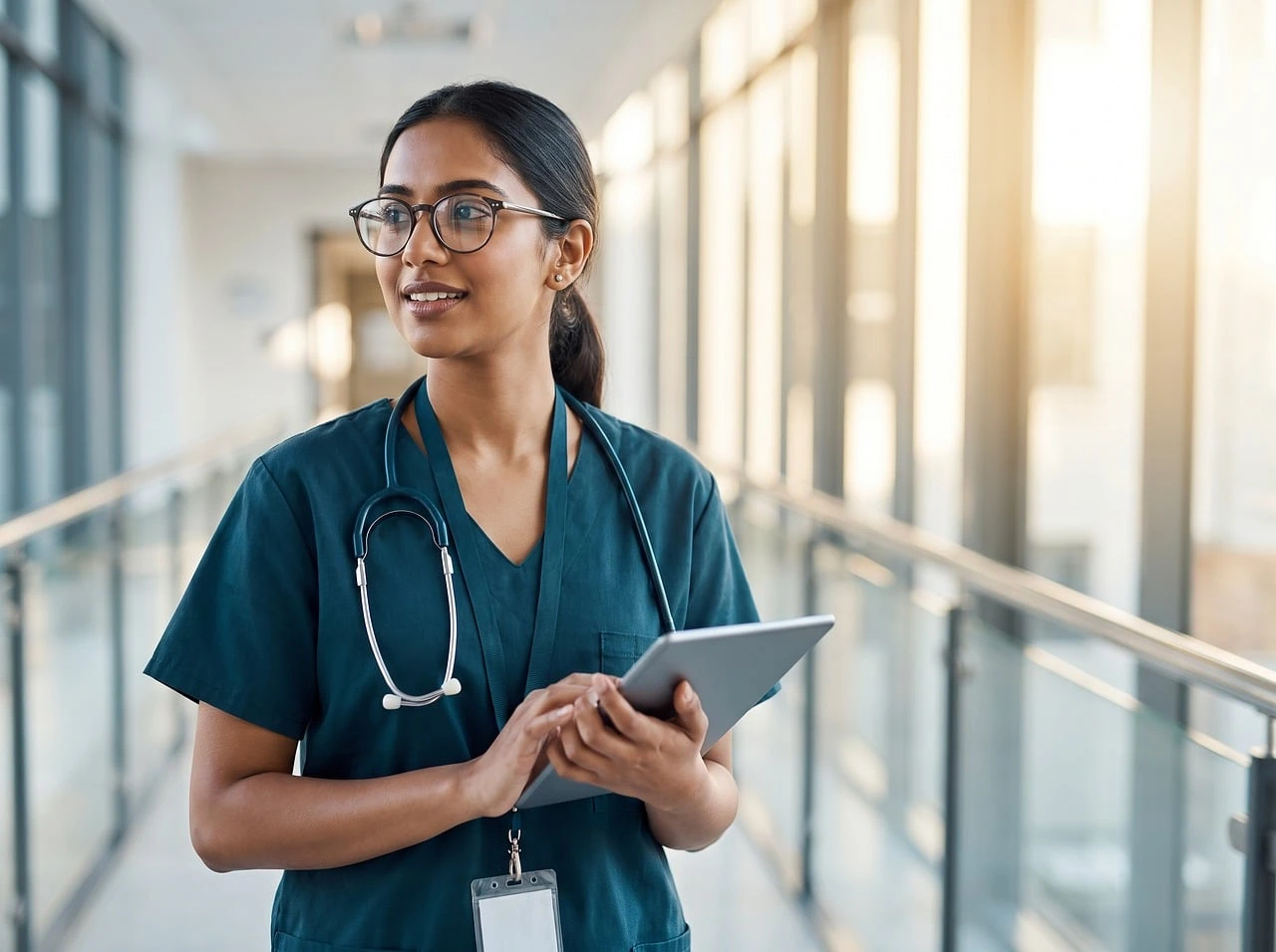 Health-care staff walk through a bright hospital corridor at a community hospital.