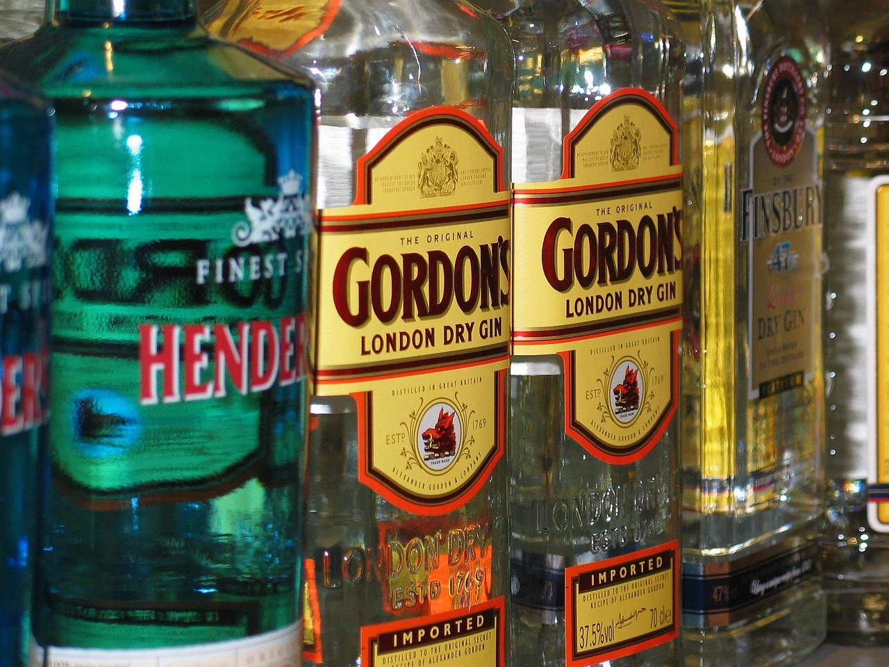 Unlabelled bottles and tasting glasses on a counter in a small restaurant setting.
