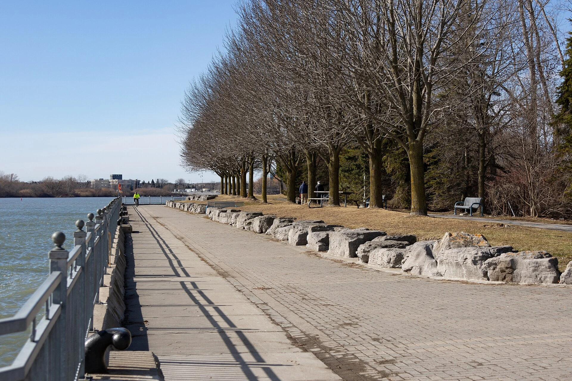 A sandy Lake Ontario beach on a sunny summer morning with a lifeguard chair and swimming buoys along the shoreline.