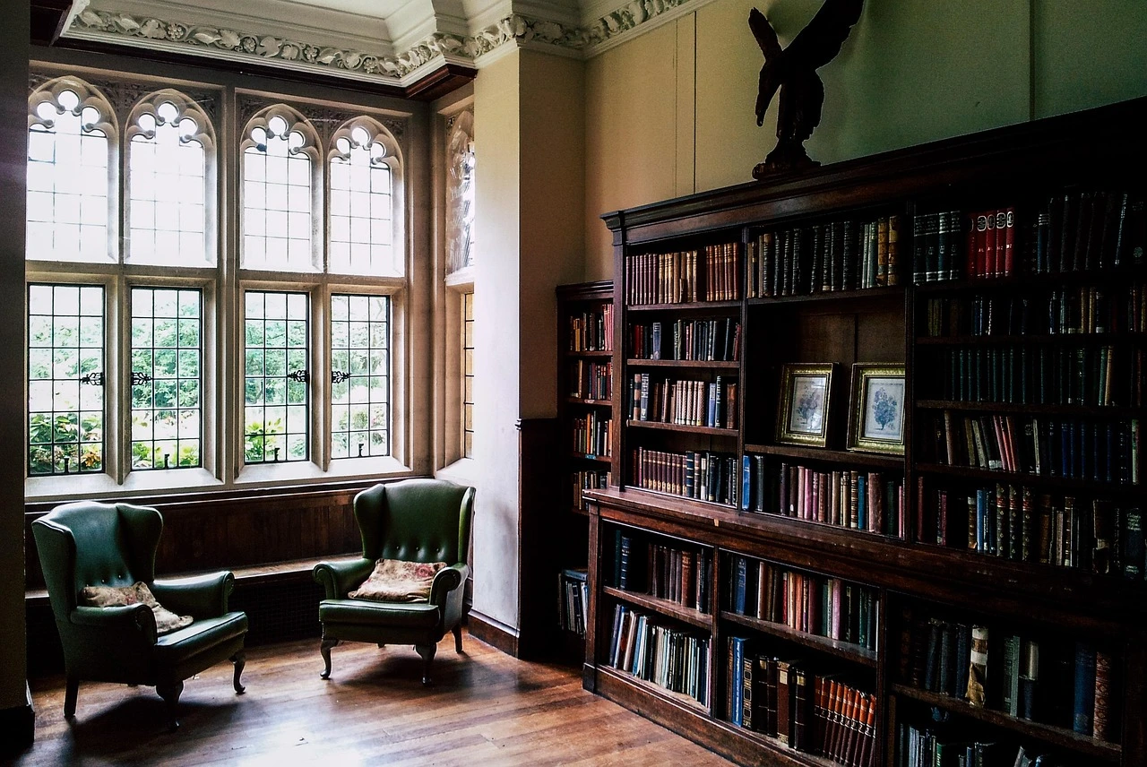 The interior of a brightly lit public library with bookshelves and a children's reading area.