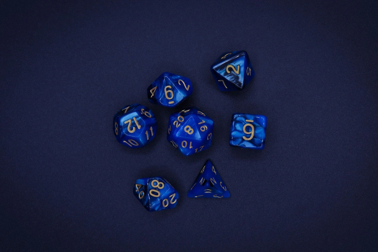 A close-up shot of tabletop gaming dice and character sheets on a wooden table in a dimly lit community centre.