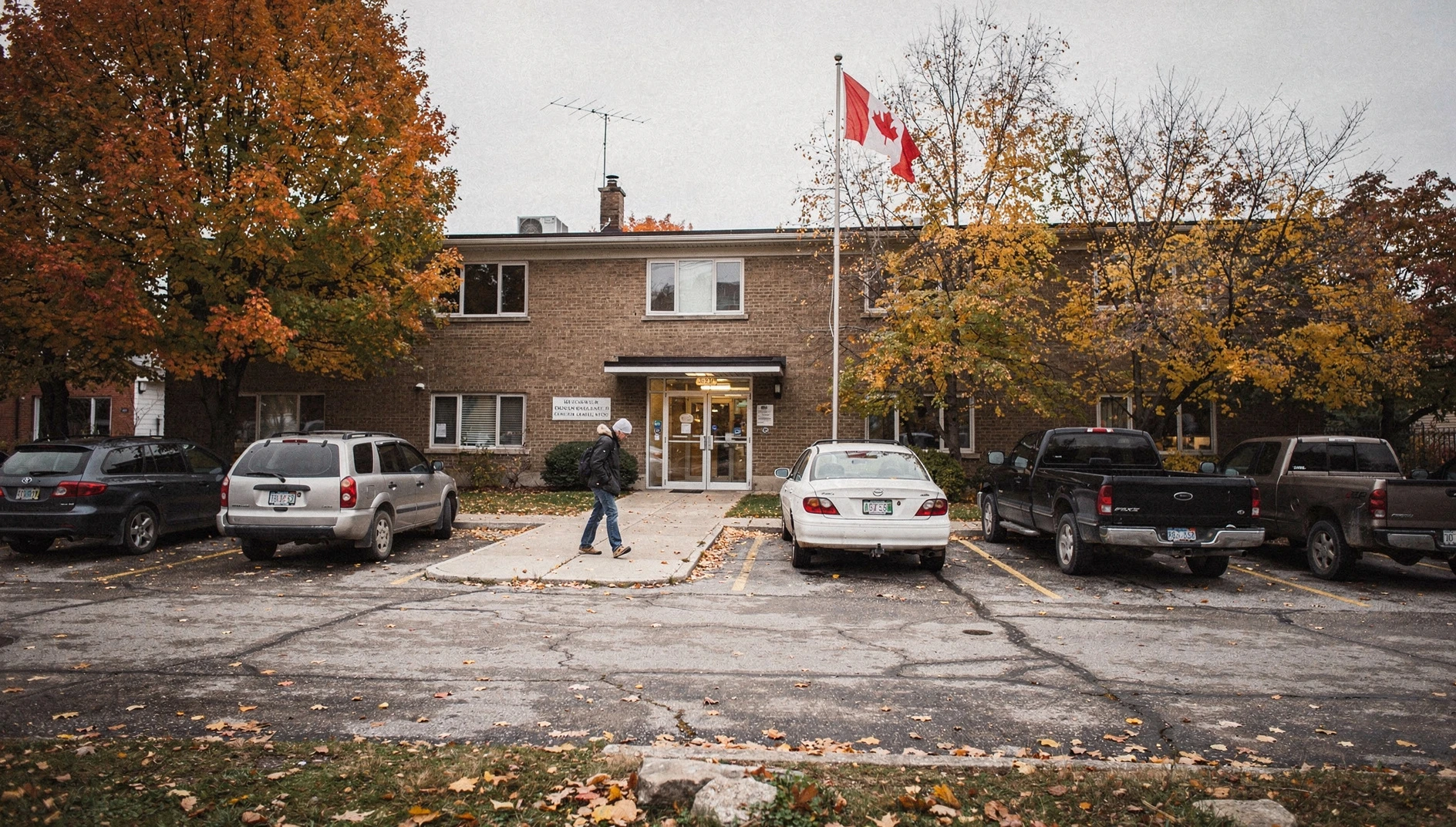 A municipal building in Grimsby surrounded by autumn trees, with a resident approaching the entrance.
