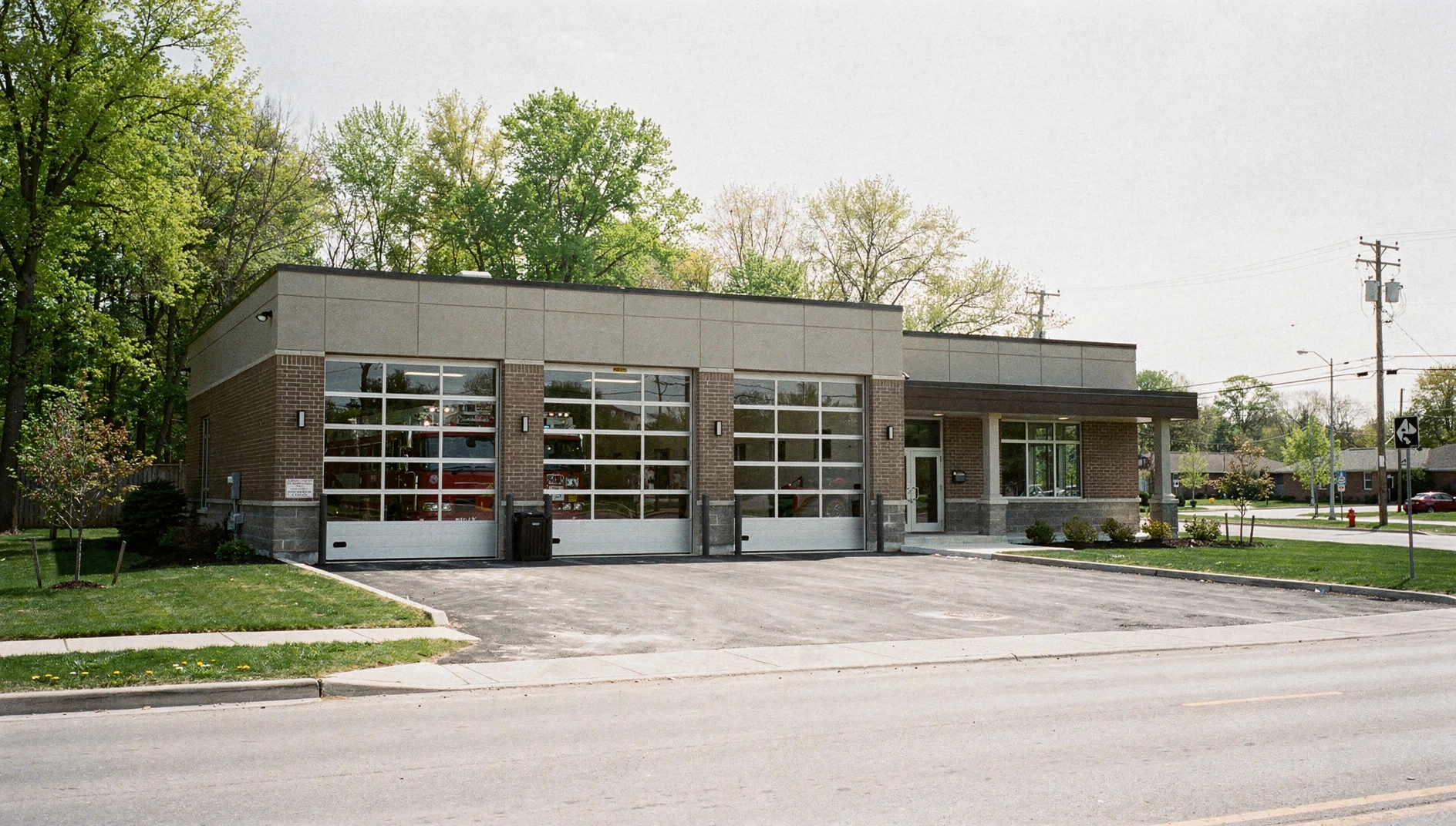 Illustrative view of a modern fire station in a suburban Ontario setting with fresh spring foliage.