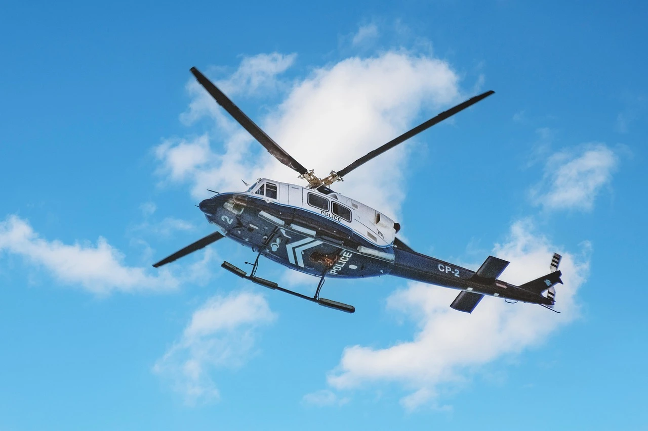 A police helicopter parked on an airfield tarmac under an overcast autumn sky