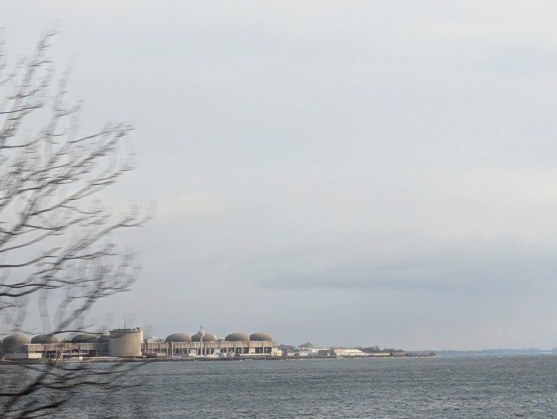 A nuclear generating station on the shore of Lake Ontario under an autumn sky.