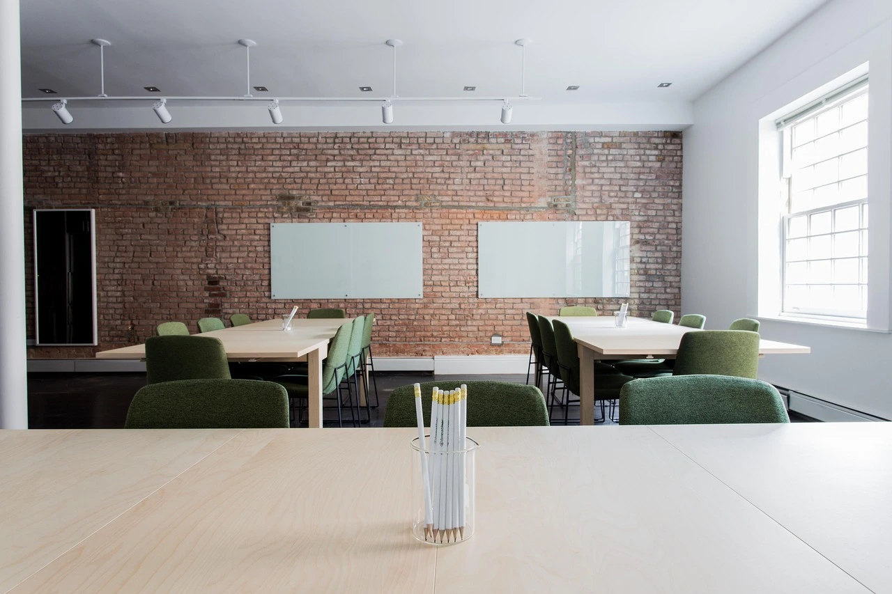 Empty rows of chairs in a school board meeting room, lit by afternoon daylight.